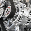 Close-up of an automotive alternator and pulleys, essential for comparing auto parts prices effectively.